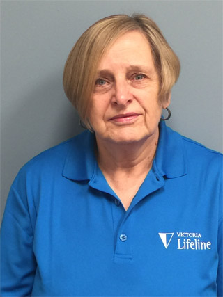 Lifeline volunteer Pat wearing a blue Lifeline shirt.